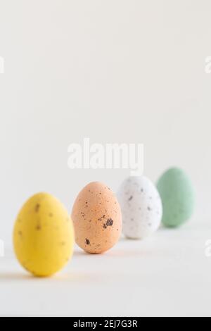 Quattro belle uova di Pasqua al cioccolato di colore pastello, un uovo rosa affilato, su sfondo bianco con spazio per la copia Foto Stock