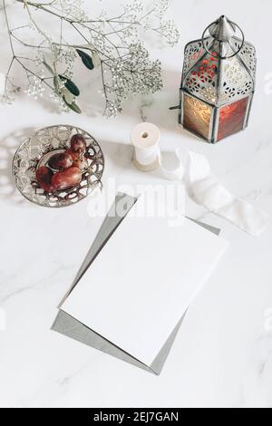 Biglietto d'auguri per la festa musulmana Ramadan Kareem, invito mockup. Marocchino d'epoca, lanterna araba. Uva su piatto d'argento. Tavolo in marmo bianco Foto Stock