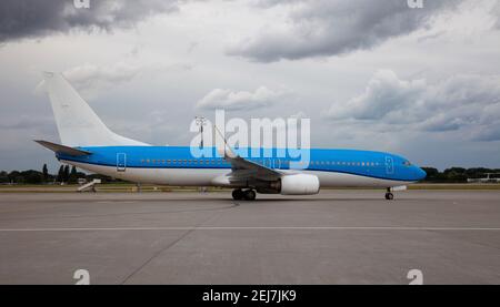 Atterra il piano di passaggio. Aereo blu sulla piattaforma dell'aeroporto. Pista. Aereo di atterraggio. Foto Stock