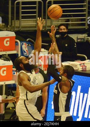 Los Angeles, Stati Uniti. 22 Feb 2021. La guardia dei Clippers di Los Angeles Paul George spara sulla guardia dei Brooklyn Nets James Harden durante la prima metà allo Staples Center di Los Angeles domenica 21 febbraio 2021. I Nets sconfissero il Clippers112-108. Foto di Jim Ruymen/UPI Credit: UPI/Alamy Live News Foto Stock