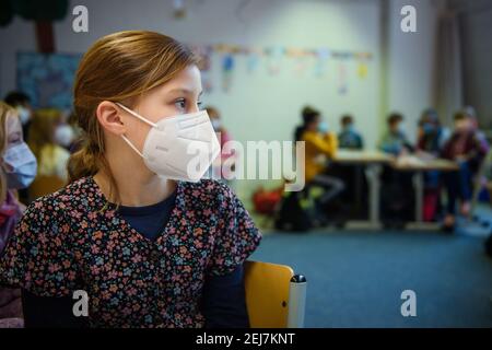 Kiel, Germania. 22 Feb 2021. Uno studente di 4° grado siede in classe alla scuola elementare Russee di Kiel indossando una maschera FFP-2. Nonostante ulteriori restrizioni di contatto per la popolazione nella crisi di Corona, i bambini delle scuole elementari e degli asili dello Schleswig-Holstein visiteranno le rispettive strutture a partire da oggi. Credit: Gregor Fischer/dpa/Alamy Live News Foto Stock