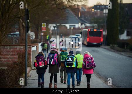 Kiel, Germania. 22 Feb 2021. Gli studenti della scuola elementare Russee di Kiel stanno per andare a scuola. Nonostante ulteriori restrizioni di contatto per la popolazione nella crisi di Corona, i bambini delle scuole elementari e degli asili nello Schleswig-Holstein devono frequentare le rispettive istituzioni a partire da oggi. Credit: Gregor Fischer/dpa/Alamy Live News Foto Stock