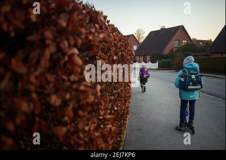 Kiel, Germania. 22 Feb 2021. Gli studenti della scuola elementare Russee di Kiel stanno per andare a scuola. Nonostante ulteriori restrizioni di contatto per la popolazione nella crisi di Corona, i bambini delle scuole elementari e degli asili nello Schleswig-Holstein devono frequentare le rispettive istituzioni a partire da oggi. Credit: Gregor Fischer/dpa/Alamy Live News Foto Stock