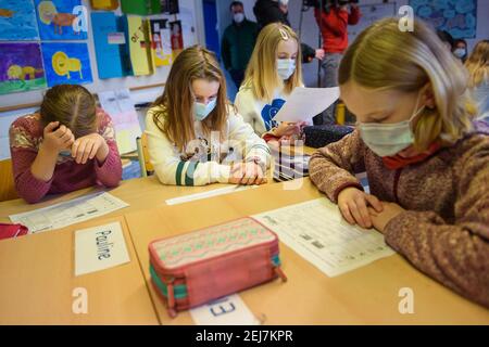 Kiel, Germania. 22 Feb 2021. Gli allievi di una classe di 4° grado leggono insieme un compito in classe alla scuola elementare Russee di Kiel. Nonostante ulteriori restrizioni di contatto per la popolazione nella crisi di Corona, gli alunni delle scuole elementari e i bambini degli asili nello Schleswig-Holstein visiteranno le rispettive strutture a partire da oggi. Credit: Gregor Fischer/dpa/Alamy Live News Foto Stock