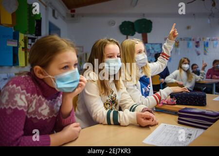 Kiel, Germania. 22 Feb 2021. Una studentessa di 4° grado alza la mano in classe alla scuola elementare Russee di Kiel. Nonostante ulteriori restrizioni di contatto per la popolazione nella crisi di Corona, i bambini delle scuole elementari e degli asili dello Schleswig-Holstein visiteranno le rispettive strutture a partire da oggi. Credit: Gregor Fischer/dpa/Alamy Live News Foto Stock