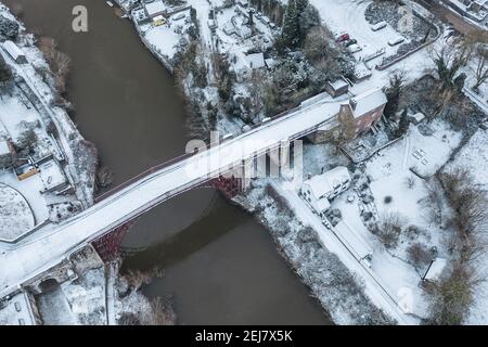 Vista aerea sul ponte in ghisa polverato da neve costruito nel 1779. Famosa meraviglia architteturale si estende sulle rive del fiume Severn in Ironbridge. Contea di SH Foto Stock