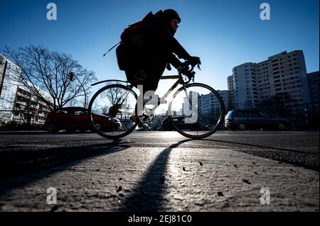 Berlino, Germania. 22 Feb 2021. Un pendolarista guida la sua bicicletta attraverso un incrocio a Berlino-Schöneberg. Credit: Fabian Sommer/dpa/Alamy Live News Foto Stock