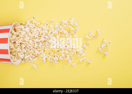 vista dall'alto del secchio di carta e dei popcorn sparsi sul concetto cinematografico giallo Foto Stock