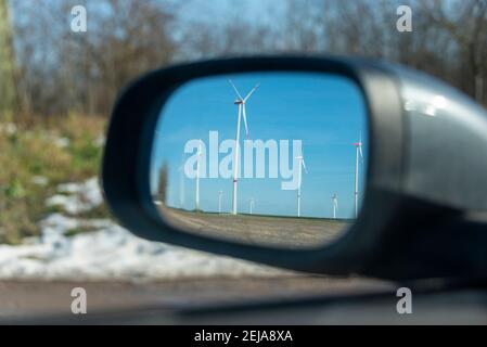 Egeln, Germania. 19 Feb 2021. Le turbine eoliche possono essere viste nello specchietto retrovisore di un'auto. L'espansione dell'energia eolica è attualmente in fase di stallo. Uno dei motivi principali: Reclami da parte di residenti e amanti della natura. Credit: Stefano Nosini/dpa-Zentralbild/ZB/dpa/Alamy Live News Foto Stock