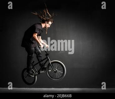 Giovane sportivo che fa acrobazie sulla sua bicicletta professionale. Sport estremi. Foto Stock