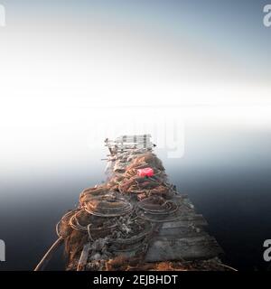 Reti da pesca su un molo di legno in mare Foto Stock