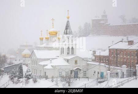 Vista della Chiesa Ortodossa invernale e del Cremlino di Nizhny Novgorod in una tempesta di neve Foto Stock