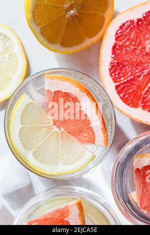 Bicchieri d'acqua con pompelmo e limone. Acqua dolce sassosa agli agrumi. Foto Stock