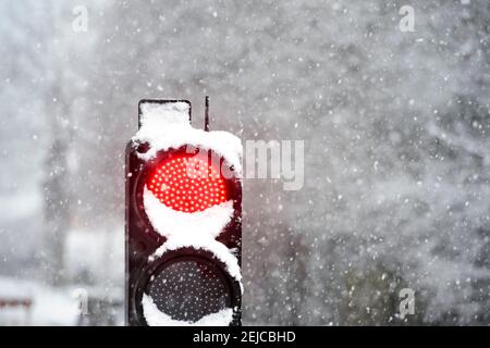 Neve che si raccoglie in cima a un semaforo in un giorno d'inverno nel Regno Unito. Foto Stock