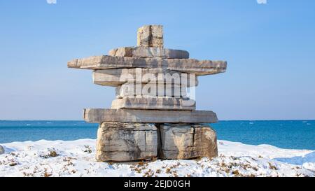 Un gigante di Inukshuk si erge affacciato sulla Georgian Bay presso il Sunset Point Park di Collingwood. Un monumento nella comunità, onorando un uomo locale. Foto Stock