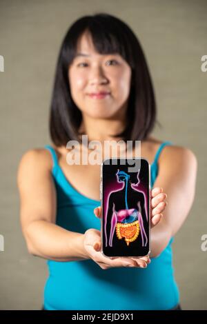 Donna che tiene schermo con disegno di sistema digestivo
