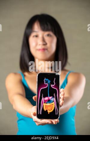 Donna che tiene schermo con disegno di sistema digestivo
