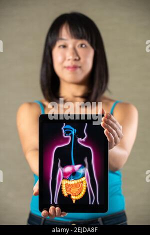 Donna che tiene schermo con disegno di sistema digestivo