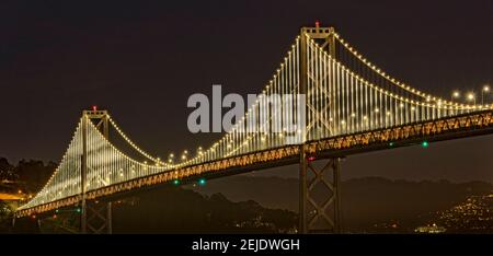 Sospensione ponte illuminato di notte, il Bay Bridge, la baia di San Francisco, San Francisco, California, Stati Uniti d'America Foto Stock