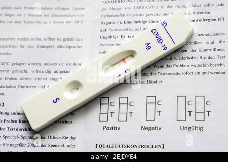 Corona Rapid test: Cassetta per test e foglietto illustrativo con le istruzioni per l'uso, mostra un test rapido con antigene Covid-19 negativo della società cinese Joinstar Biomedical utilizzando un campione di saliva. --- Corona-Schnelltest: Testkassette und Beipacchettel mit der Gebrauchsanweisung, sie zeigt einen durch eine Speichelprobe vorgenommenen negativen Covid-19 Antigen-Schnelltest der chinesischen Firma Joinstar Biomedical. Foto Stock