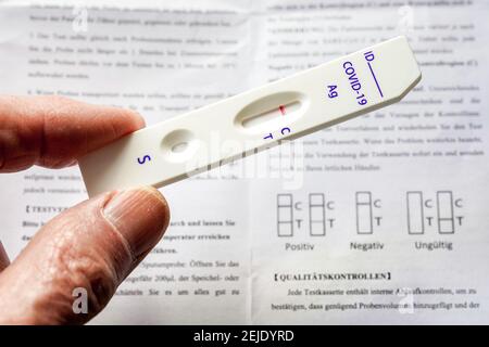 Corona Rapid test: Cassetta per test e foglietto illustrativo con le istruzioni per l'uso, mostra un test rapido con antigene Covid-19 negativo della società cinese Joinstar Biomedical utilizzando un campione di saliva. --- Corona-Schnelltest: Testkassette und Beipacchettel mit der Gebrauchsanweisung, sie zeigt einen durch eine Speichelprobe vorgenommenen negativen Covid-19 Antigen-Schnelltest der chinesischen Firma Joinstar Biomedical. Foto Stock