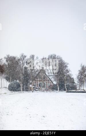 Piccolo cottage a graticcio in forte nevicata Foto Stock