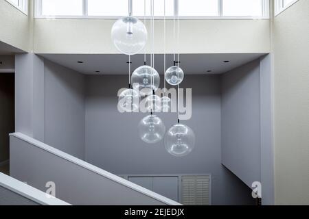 Un lampadario contemporaneo appeso su una scala in una grande casa. Foto Stock