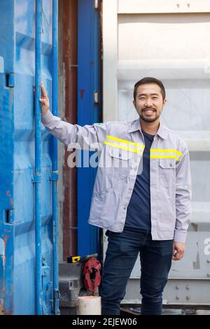 Ritratto del sorriso del lavoratore o del tecnico e del contenitore in piedi Foto Stock
