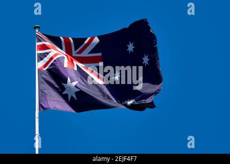 Primo piano sulla bandiera dell'Australia sventolando in cima al suo palo. Foto Stock