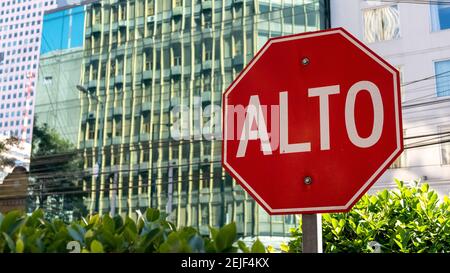 Città del Messico, Messico - 21 novembre 2016: Una vista generale di un cartello stradale ALTO (Stop), con blocchi di uffici sullo sfondo Foto Stock
