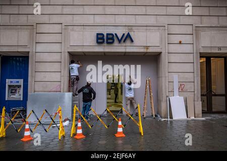 Barcellona, Spagna. 22 Feb 2021. Gli operatori sono visti rinforzare la porta della BBVA Bank a Passeig de Gràcia contro il vandalismo.più di 50 negozi hanno subito danni alle loro vetrine e alcuni sono stati saccheggiati a Passeig de Gràcia durante le rivolte a seguito delle dimostrazioni per la libertà di rapper Pablo Hasel. Credit: SOPA Images Limited/Alamy Live News Foto Stock