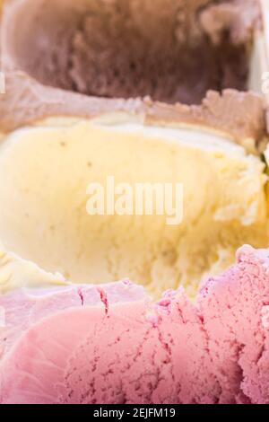 gelato commestibile (fragola, vaniglia e cioccolato) - alcuni scoop già tolto dalla scatola del gelato Foto Stock