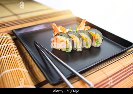 sushi roll su un piatto nero pronto per essere servito Foto Stock