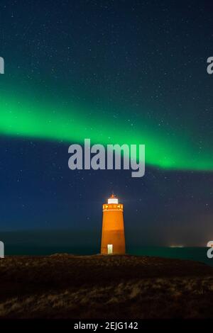 Faro sulla penisola di Reykjanes nortern sotto le luci. L'Islanda. Il timelapse Foto Stock