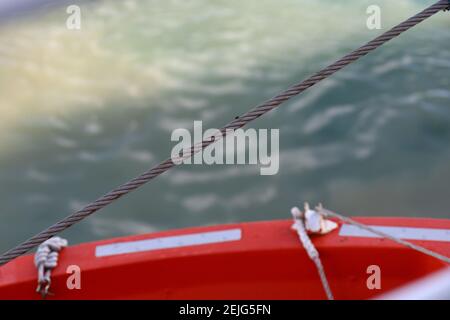 Primo piano di falciatrice di metallo che fissa una scialuppa di salvataggio su una nave Foto Stock