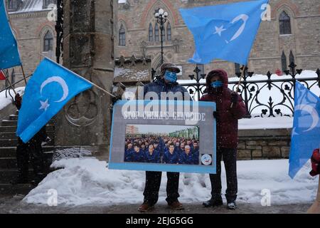 Ottawa, Canada. 22 febbraio 2021. Mentre il Parlamento canadese discute una mozione per dichiarare formalmente i crimini contro i musulmani di Uyghur in Cina un genocidio, un raduno organizzato dall'Associazione del Turkistan orientale del Canada davanti al Parlamento ad Ottawa per sostenere la mozione. Il gruppo di persone è venuto a protestare per il genocidio in corso dei musulmani di Uyghur per mano dell'attuale regime cinese. Chiede azioni concrete da parte del governo canadese per condannare le azioni e dichiararle un genocidio. Credit: Meanderingemu/Alamy Live News Foto Stock