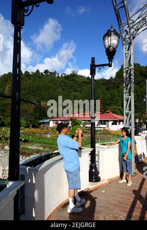 Uomo che scatta foto di sua figlia sul ponte sul fiume Caldera, Boquete, provincia di Chiriqui, Panama Foto Stock