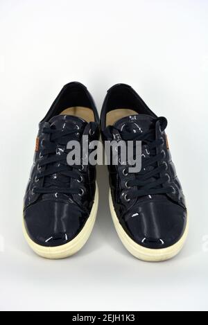 Eleganti scarpe laccate nere lucide su sfondo bianco. Mocassini in vera  pelle con tulshit e lacci larghi neri. Sneake da donna Foto stock - Alamy