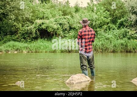 attività di passione. Pesca a mosca riuscita. Fine settimana estivo. pescatore esperto in acqua. fisherman mostra tecnica di pesca utilizzare canna. attività sportiva e ho Foto Stock