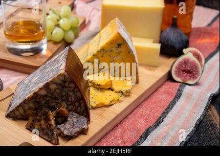 Formaggio irlandese marrone, formaggio blu e un bicchiere di degustazione di un piatto unico whisky irlandese da vicino Foto Stock