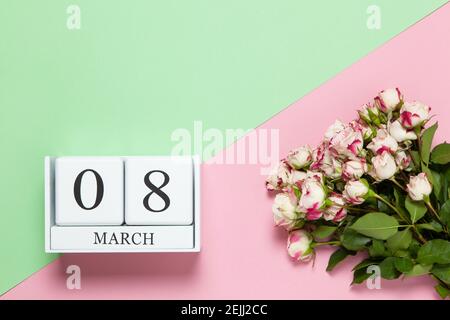 Calendario perpetuo con data 8 marzo, bouquet di piccole rose su sfondo bicolore rosa e verde. Disposizione piatta. Vista dall'alto. International Happy Women's D Foto Stock