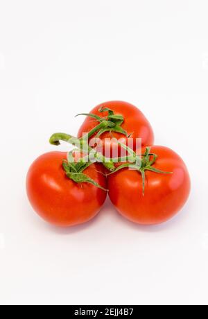 Tre pomodori maturati freschi di vite grande. Foto Stock