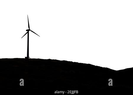 Isolato su sfondo bianco, silhouette di una turbina eolica all'orizzonte. Turbine eoliche nelle campagne dell'altopiano di Paul da Serra, isola di Madeira, Foto Stock