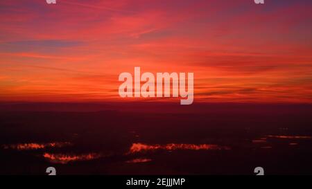 Cielo rosso-arancione dopo il tramonto. Le nuvole rosse si riflettono nei laghi. Fotografia aerea, scatto di moody. Foto perfette per lo scambio di sfondo. Foto Stock