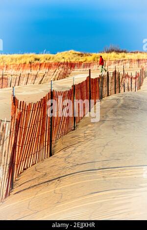 Recinzione da neve con ombre lungo la sabbia che si dondeggia nel vento vicino al Ludington state Park Beach House sul lago Michigan vicino a Ludington, Michigan, USA. Ludington, S. Foto Stock