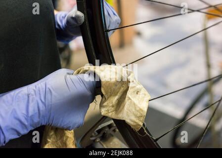 primi piani con i dettagli di un meccanico che effettua la manutenzione delle parti di ricambio su una bicicletta. Foto Stock