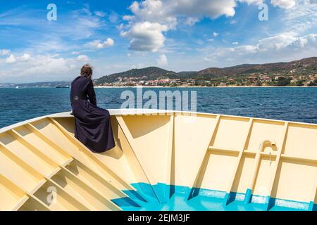 Il vecchio monaco guarda le montagne Athos su una nave in una giornata estiva Foto Stock