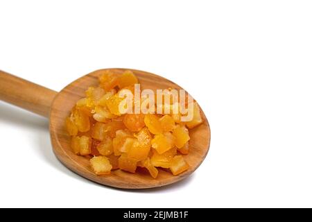 Buccia d'arancia candita su un cucchiaio di legno contro un bianco sfondo Foto Stock