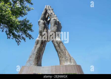 06-11-2020 Tulsa USA - Giant pregando mani statua a Oral Roberts University - dice che la morte è inghiottita in Vittoria - contro il cielo blu con albero Foto Stock