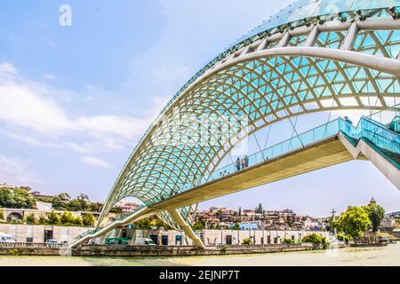 019 07 19 Tbilisi Georgia - Ponte della Pace - a forma di arco ponte pedonale in acciaio e vetro illuminato con numerosi LED sulla K Foto Stock